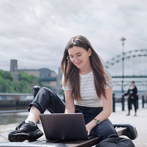 student in front of tyne bridge