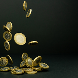 Pound coins falling into a pile