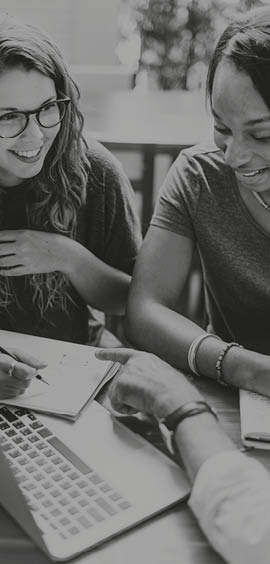 a woman sitting at a table using a laptop