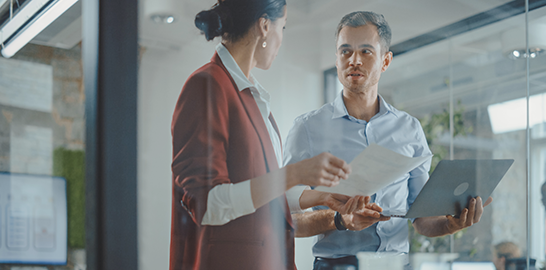 Male and female coworkers stood in a meeting room