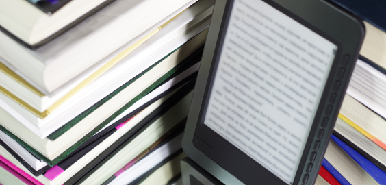A solitary e-book among a stack of books