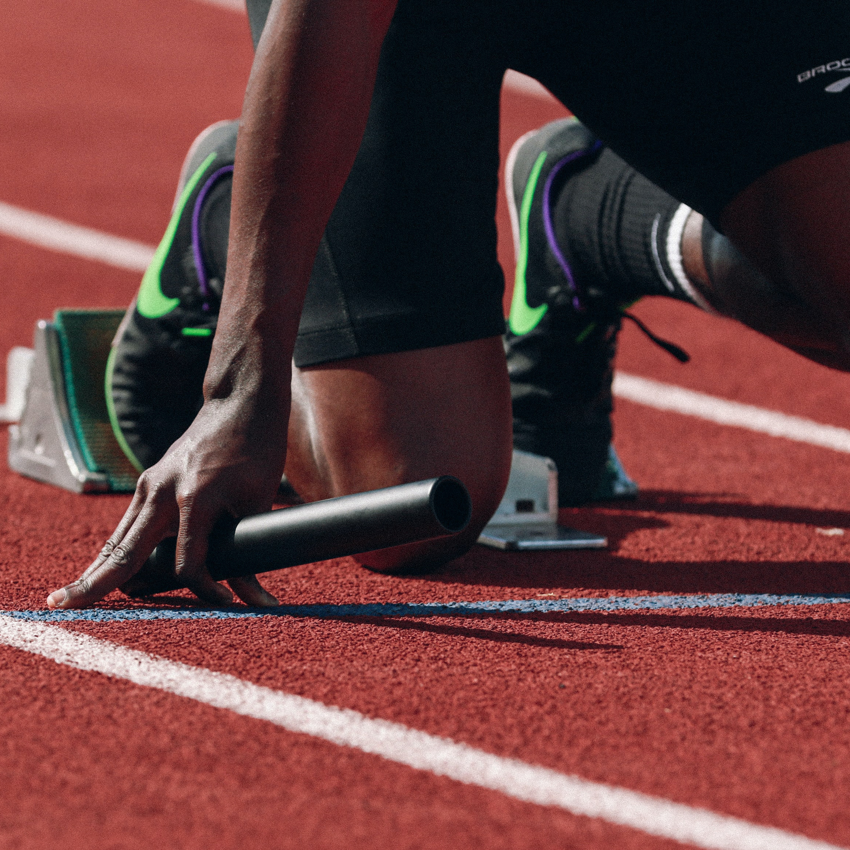 a  close up of a relay runner preparing to start a race