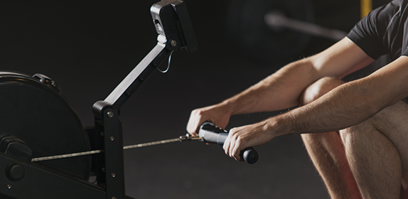 Close-up of an individul using a rowing machine.