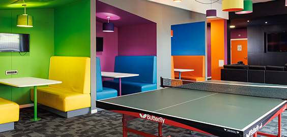 Colourful accommodation communal area with booths and table tennis table