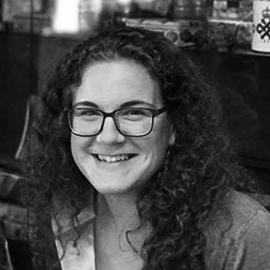 a person wearing glasses and smiling at the camera