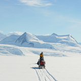 a man riding skis down a snow covered mountain