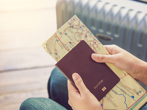 hands holding a map and a passport