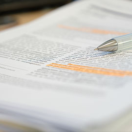 Paper document with highlighted text and pen