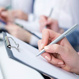 hand taking notes on clipboard