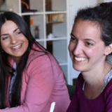 Two smiling women sitting at a table