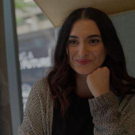 Female student smiling directly at the camera, whilst talking to a staff member within the Graduate Futures team.