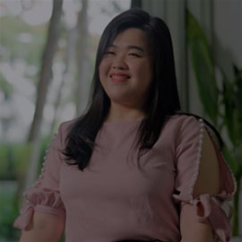 Malaysian alumni Tian Nee is looking directly at the camera and smiling.