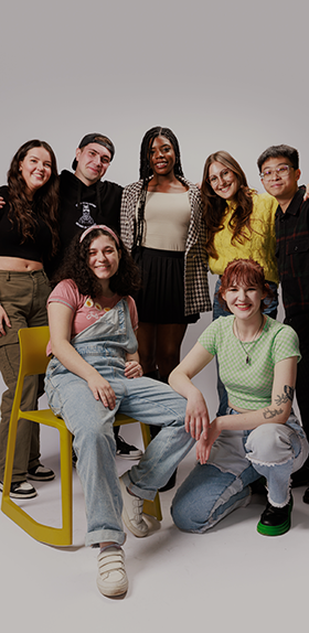 Group of multi-cultural students stood in a group, smiling and looking directly at the camera as part of the 'I Am Northumbria' campaign