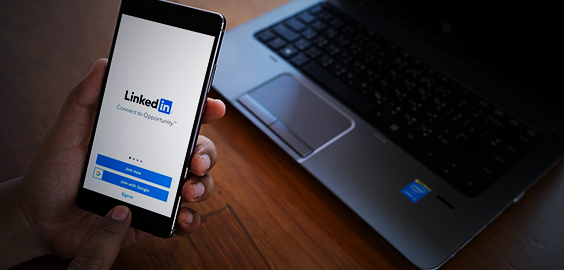 a hand holding a small laptop is sitting on a table