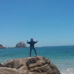 a group of people on a rocky beach next to the ocean