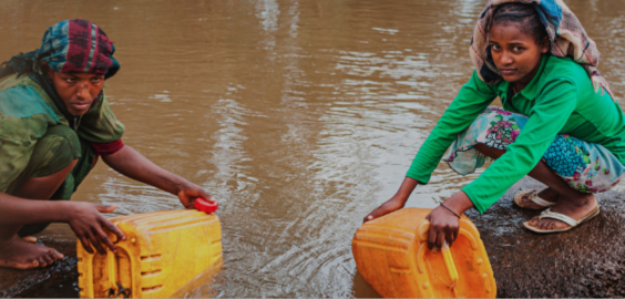 people crouched by a river