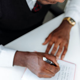 Image of man writing on paper