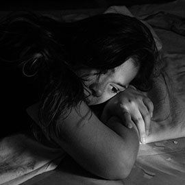 Image of a woman resting her head in her arms