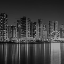 a bridge over a body of water with a city in the background