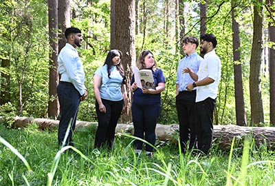 group of students talking in the woods