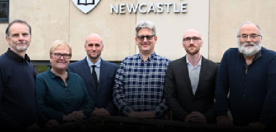 four men smiling to camera