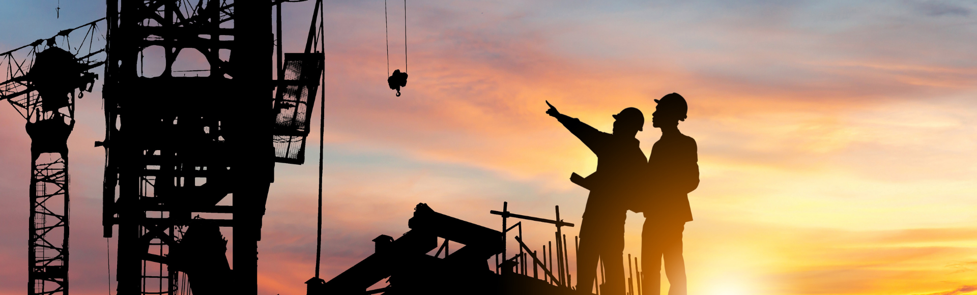 two people in hard hats are silouetted against a sunset sky with the outline of cranes behind the to signify engineering