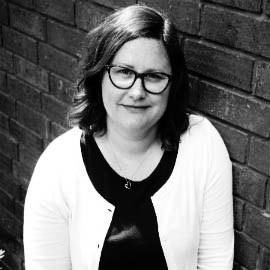 a person standing in front of a brick wall