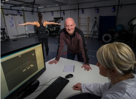 a man and a woman standing in front of a computer