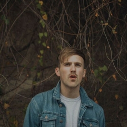 a man standing in front of a forest