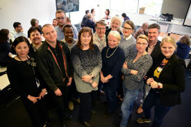 a group of people standing in front of a crowd posing for the camera