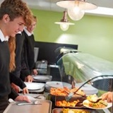 a man and woman preparing food in a kitchen