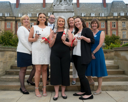 a group of people posing for a photo in front of a building