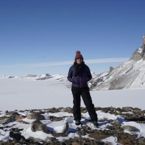 a person standing near snow covered mountains in the background
