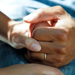 Hands clasped in a caring way