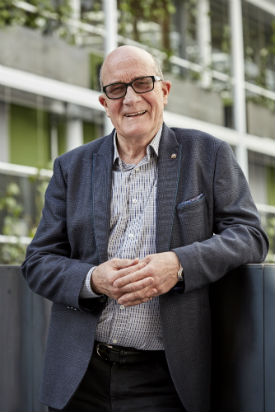 a man standing next to a fence