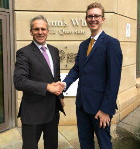 a person in a suit standing in front of a building