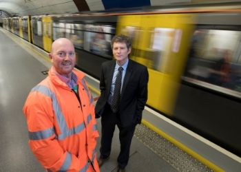 a person standing next to a train station