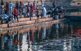 a group of people standing next to a body of water
