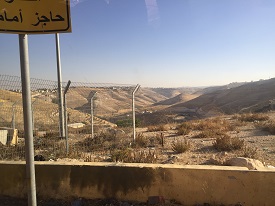 a sign on the side of a dirt field