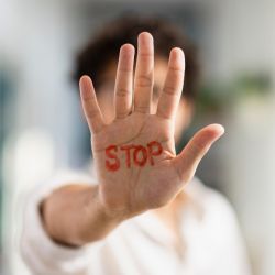 Image of a hand with stop written on it