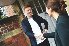 a person standing next to a brick wall