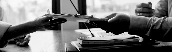 Hands passing a clipboard