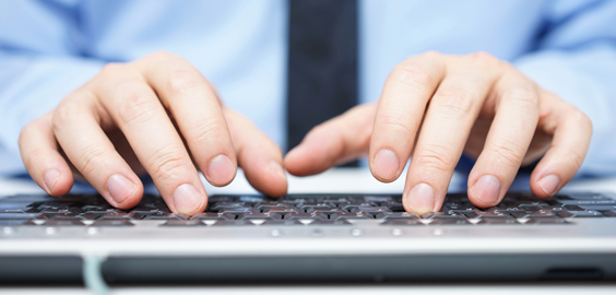 a person using a laptop computer sitting on top of a keyboard