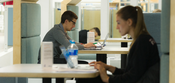 a man and a woman standing in front of a computer
