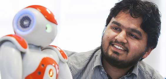 a man wearing glasses and smiling at the camera