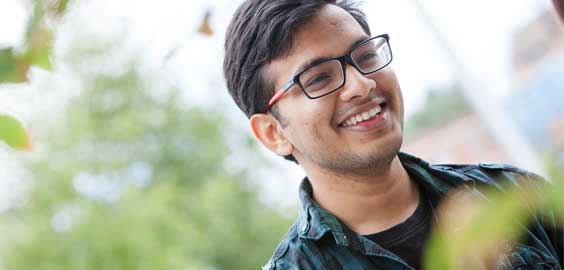 a man wearing glasses and smiling at the camera