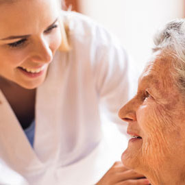 Female clinician smiling at older patient