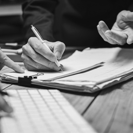 a person using a laptop computer sitting on top of a wooden table