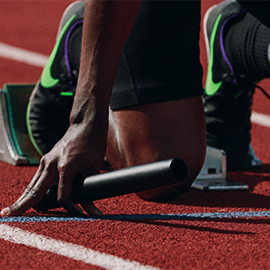 runner on racetrack kneeling in starting position