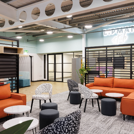 Modern, open plan room with bright chairs and tables.